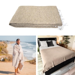 May include: A folded beige blanket with white fringe. The blanket is made of a woven material and has a tag that reads "west path". The blanket is shown on a bed and wrapped around a person.