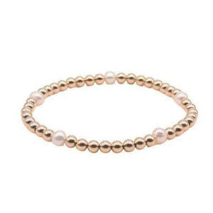 May include: A rose gold beaded bracelet with four white pearls.
