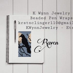 May include: A beaded pen wrap featuring a black raven design on a blue and tan background. The pen wrap is displayed on a grid-lined notebook with a black pen. Text includes "K Wynn Jewelry" and "Raven".