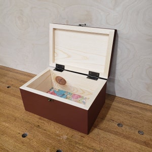 May include: A wooden box with a hinged lid, painted a deep red color. The inside of the box is lined with a printed paper map.