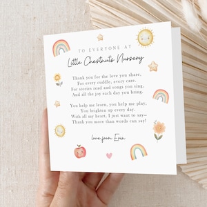 May include: A white card with a watercolour design and text. The card features a rainbow, sun, stars, and flowers. The text reads "To Everyone at Little Chestnuts Nursery" and a thank you message. The card is held by a person.