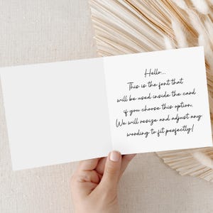 May include: A white, folded greeting card held open, displaying handwritten text in black cursive font. The text reads, "Hello... This is the font that will be used inside the card if you choose this option. We will resize and adjust any wording to fit perfectly!"