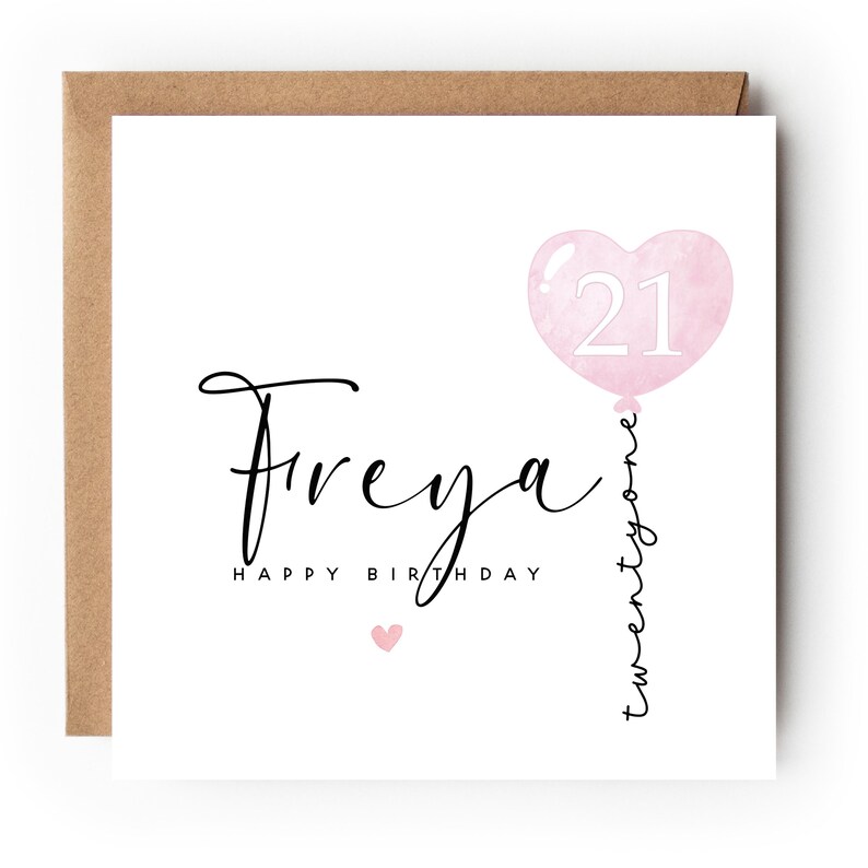 May include: A square birthday card with a brown envelope. The card features the name "Freya" in elegant script, with "Happy Birthday" below. A pink heart-shaped balloon with the number "21" is on the right, with "twenty one" written vertically.