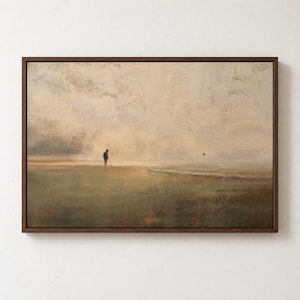 Puede incluir: Un cuadro de paisaje enmarcado que muestra una figura solitaria en un campo de golf en un entorno brumoso de tonos beige y verdes. La obra representa a un golfista sosteniendo un palo cerca de una bandera, con pinceladas visibles y texturizadas.