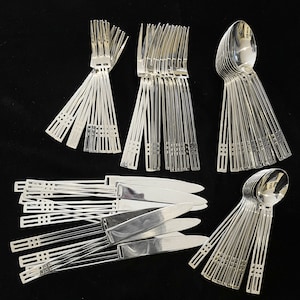 May include: A set of silver flatware, including forks, knives, and spoons. The flatware is arranged in a fan shape, with the handles facing up. The flatware is made of polished silver and has a simple, elegant design.