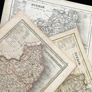 May include: A collection of antique maps, featuring detailed cartography of Durham and Northumberland. The maps are printed on aged paper, with visible text and intricate line work. The maps are in shades of beige, brown, and black.