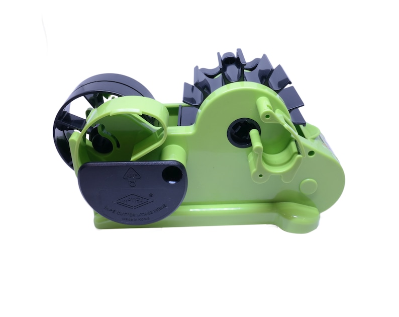 May include: A green and black tape dispenser with a clear tape roll. The dispenser has a black handle and a black label that says "D-C Tape Cutter, Japan Made, Made in China".