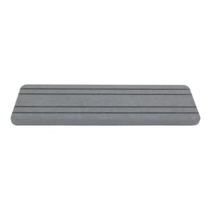 May include: A rectangular, gray, foam step with four dark gray horizontal stripes. The step has rounded edges and is designed for use in a bathroom or shower. The step is made of a durable, non-slip material.