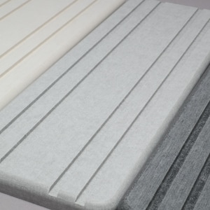 May include: Close-up of three rectangular, textured, light-colored surfaces with parallel grooves. The surfaces are in shades of white, gray, and dark gray. The grooves run diagonally across the surfaces, creating a textured pattern.