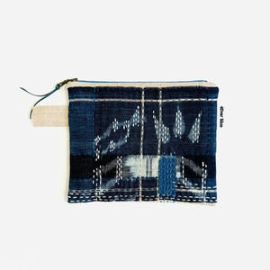 May include: A rectangular zippered pouch made of dark blue and indigo fabric with a white grid pattern and white sashiko-style stitching. The pouch features a small side tab and the text 4Ever Blue printed on the right edge near the zipper.