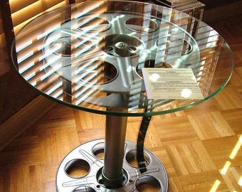 Movie Reel table made from repurposed 35mm movie reels with film choice of colors. 18" Round tempered glass top. Game Room Home Theater