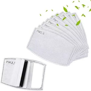 May include: A stack of white PM2.5 filter replacements, with a single filter partially assembled. The filters are rectangular with a stitched border and the text "PM2.5" printed on them. Green leaf accents are scattered around the filters.