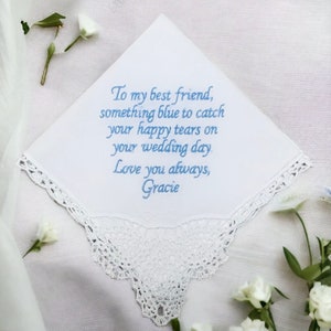 Our customizable white Something New,  Something Blue handkerchief on a white background with white flowers scattered around it.