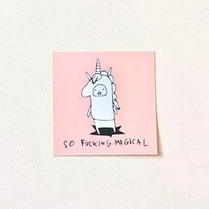May include: A pink card with a black and white illustration of a person wearing a unicorn costume. The text "SO FUCKING MAGICAL" is printed below the illustration.