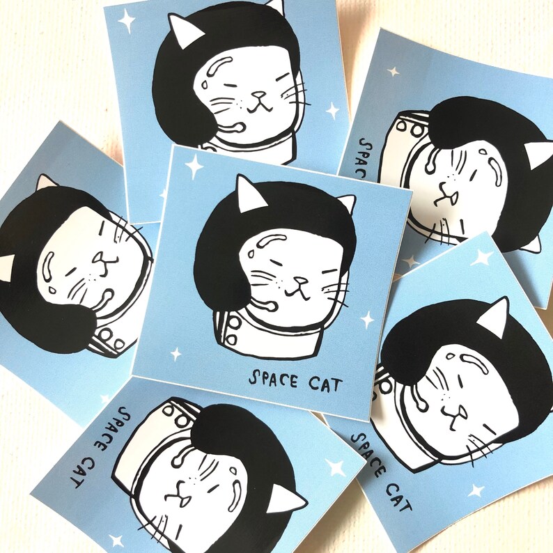 K&ouml;nnte beinhalten: Sechs blaue und wei&szlig;e illustrierte Karten mit dem Text "Space Cat" auf jeder Karte. Jede Karte zeigt eine Schwarzwei&szlig;illustration einer Katze mit einem Weltraumhelm.