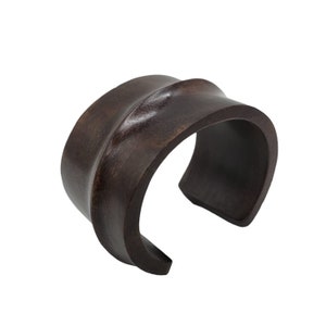 a wooden cuff bracelet with a black finish