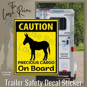May include: Yellow and black caution sign with a silhouette of a donkey and the text "CAUTION PRECIOUS CARGO On Board".