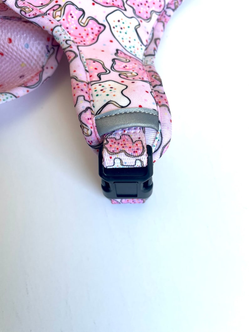 May include: Pink dog collar with a cookie pattern and a black plastic buckle.