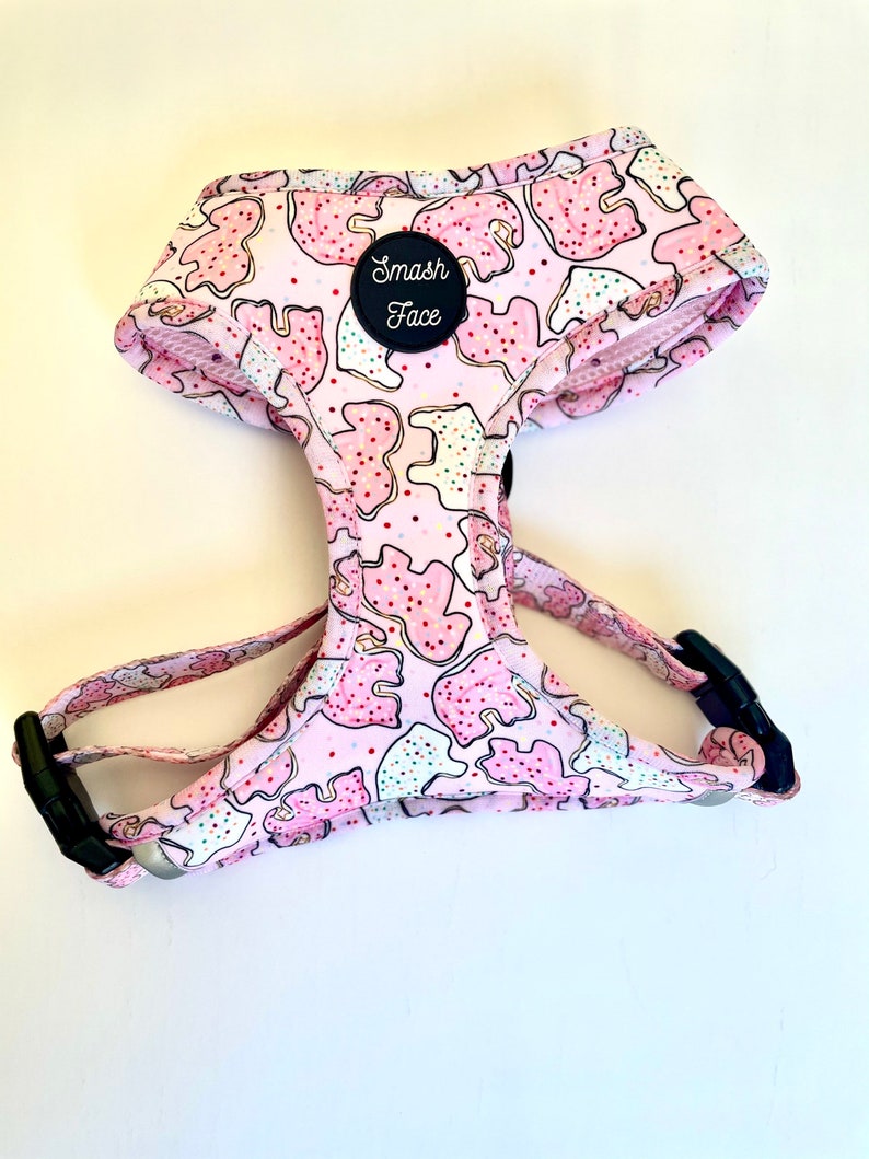 May include: Pink dog harness with a cookie pattern and a black patch that says "Smash Face".