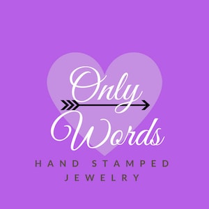 May include: A purple background with a white heart shape containing the text "Only Words" with an arrow pointing to the right. Below the heart is the text "HAND STAMPED JEWELRY".