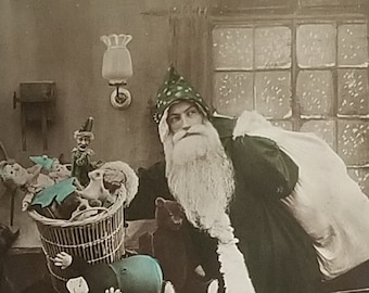 Real Photo Style Postcard Hand Tinted Santa Claus in Green Robe Bringing Toys