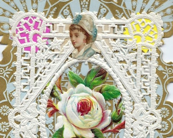 Puede incluir: Un doily de papel de encaje vintage con un borde dorado y un centro blanco. El doily tiene un diseño recortado y presenta una imagen floral con una rosa blanca y hojas verdes. El texto "To the One I love." está impreso en una pequeña etiqueta rectangular de papel.