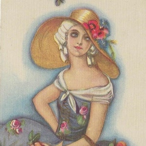 May include: A woman wearing a large straw hat with a floral embellishment sits on a floral patterned fabric. She holds a red apple in her hand. A basket of fruit sits in front of her.