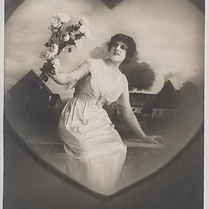 Artist Postcard Woman in Heart Frame Holding Flowers House Scene in Background Monochromatic Color