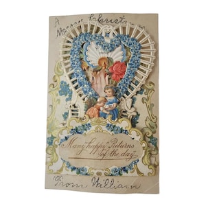 May include: Vintage greeting card with a heart-shaped design. The card features a heart-shaped frame with blue floral accents, a red rose, and two children. The text "Many happy Returns of the day" is displayed on the card, along with the name "William".