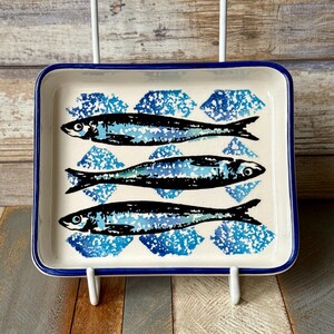 Plato de cerámica portugués hecho a mano con tres peces: sardinas y anchoas.