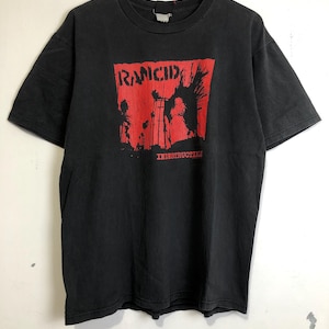 Puede incluir: Camiseta negra con un gráfico rojo de la banda Rancid. El gráfico presenta el nombre de la banda y la palabra "Indestructible".