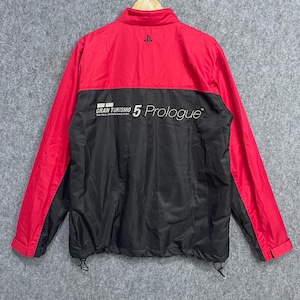 May include: A red and black Gran Turismo 5 Prologue jacket. The jacket features a red upper section and sleeves, contrasted by a black lower section. The text "Gran Turismo 5 Prologue" is printed on the back, with the PlayStation logo above.