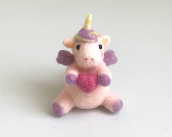 Unicornio de fieltro con aguja con un corazón rosa