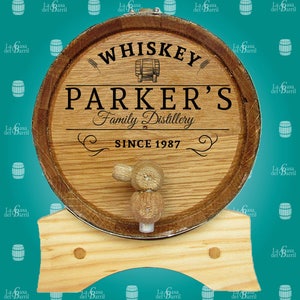 May include: A wooden barrel with a metal band and a wooden tap. The barrel is labelled "Whiskey Parker's Family Distillery Since 1987".