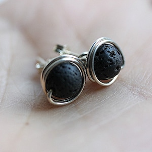 May include: A pair of silver wire wrapped earrings with black lava rock beads.