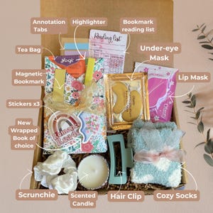 May include: A gift box filled with self-care and reading essentials. Includes a new wrapped book, tea bag, face masks, cozy socks, scrunchie, hair clip, scented candle, and a reading list. Also includes a magnetic bookmark, annotation tabs, highlighter, and stickers.