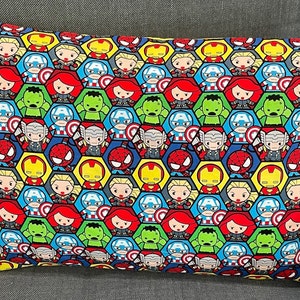 May include: A yellow pillow with a colorful pattern of superhero characters. The characters are in a honeycomb pattern and include Iron Man, Captain America, Thor, Hulk, Spider-Man, and Black Widow.