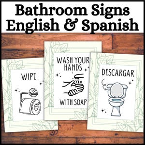 May include: Bathroom signs in English and Spanish. Three framed prints with bathroom instructions. One says "Wipe" with a toilet paper roll graphic. Another says "Wash Your Hands With Soap". The last says "Descargar" with a toilet graphic.