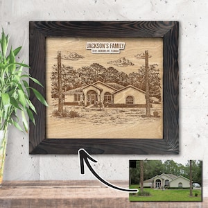 May include: A framed wooden plaque featuring an engraved image of a house, trees, and clouds. The text "JACKSON'S FAMILY" and address are at the top. The frame is dark brown. A smaller photo of the house is in the bottom right corner.