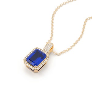 This is a classic and elegant 14K solid gold Emerald cut blue Sapphire pendant, set with a sparkling halo of white diamonds, the perfect anniversary or bridal necklace.