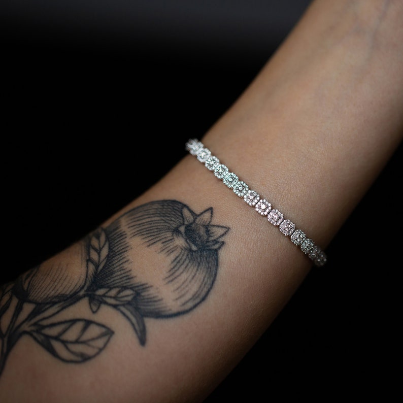 This unique diamond tennis bracelet features stunning pave set diamond clusters on cushion shape links that sparkle and shine with every movement.