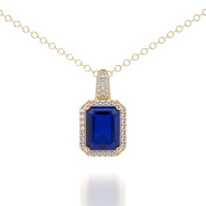 This is a classic and elegant 14K solid gold Emerald cut blue Sapphire pendant, set with a sparkling halo of white diamonds, the perfect anniversary or bridal necklace.