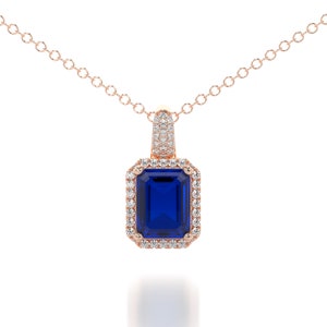 This is a classic and elegant 14K solid gold Emerald cut blue Sapphire pendant, set with a sparkling halo of white diamonds, the perfect anniversary or bridal necklace.