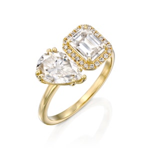 This is a stunning double-stone engagement ring, the perfect two-stone diamond ring, set with pear and emerald cut moissanite, surrounded by a halo of white diamonds, a unique toi et moi engagement ring.