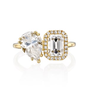 This is a stunning double-stone engagement ring, the perfect two-stone diamond ring, set with pear and emerald cut moissanite, surrounded by a halo of white diamonds, a unique toi et moi engagement ring.