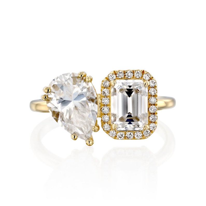 This is a stunning double-stone engagement ring, the perfect two-stone diamond ring, set with pear and emerald cut moissanite, surrounded by a halo of white diamonds, a unique toi et moi engagement ring.