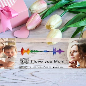 Pu&ograve; includere: Un blocco di acrilico trasparente con due foto di una madre e un bambino, e una donna. Il blocco presenta anche un'onda sonora arcobaleno, un codice QR e il testo "I love you Mom".