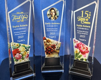 Puede incluir: Tres placas de premio de acrílico transparente con letras doradas y diseños florales. La placa superior dice "Thank You Sophia Roberts" y "Excellence Rewarded Success Recognized 2025 Tina&Co". La placa del medio dice "Emily Anderson Excellence Rewarded Success Recognized 2025 Tina&Co". La placa inferior dice "15 Years of Service Sophia Roberts Excellence Rewarded Success Recognized 2025 Tina&Co".