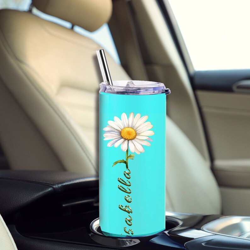 Puede incluir: Un vaso de acero inoxidable turquesa con una margarita blanca y el texto "fab-o-lla" en verde. El vaso tiene una tapa y una pajita.