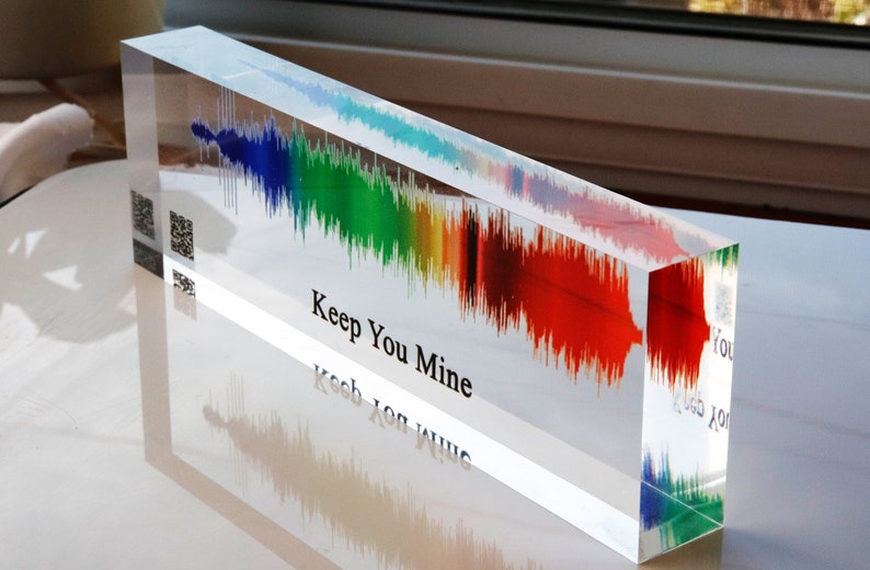 May include: A clear acrylic block with a rainbow-colored sound wave embedded inside. The text "Keep You Mine" is printed on the bottom of the block.